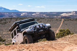 Heavily loaded JK wrangler overcoming an obstacle with AEV high capacity coil springs