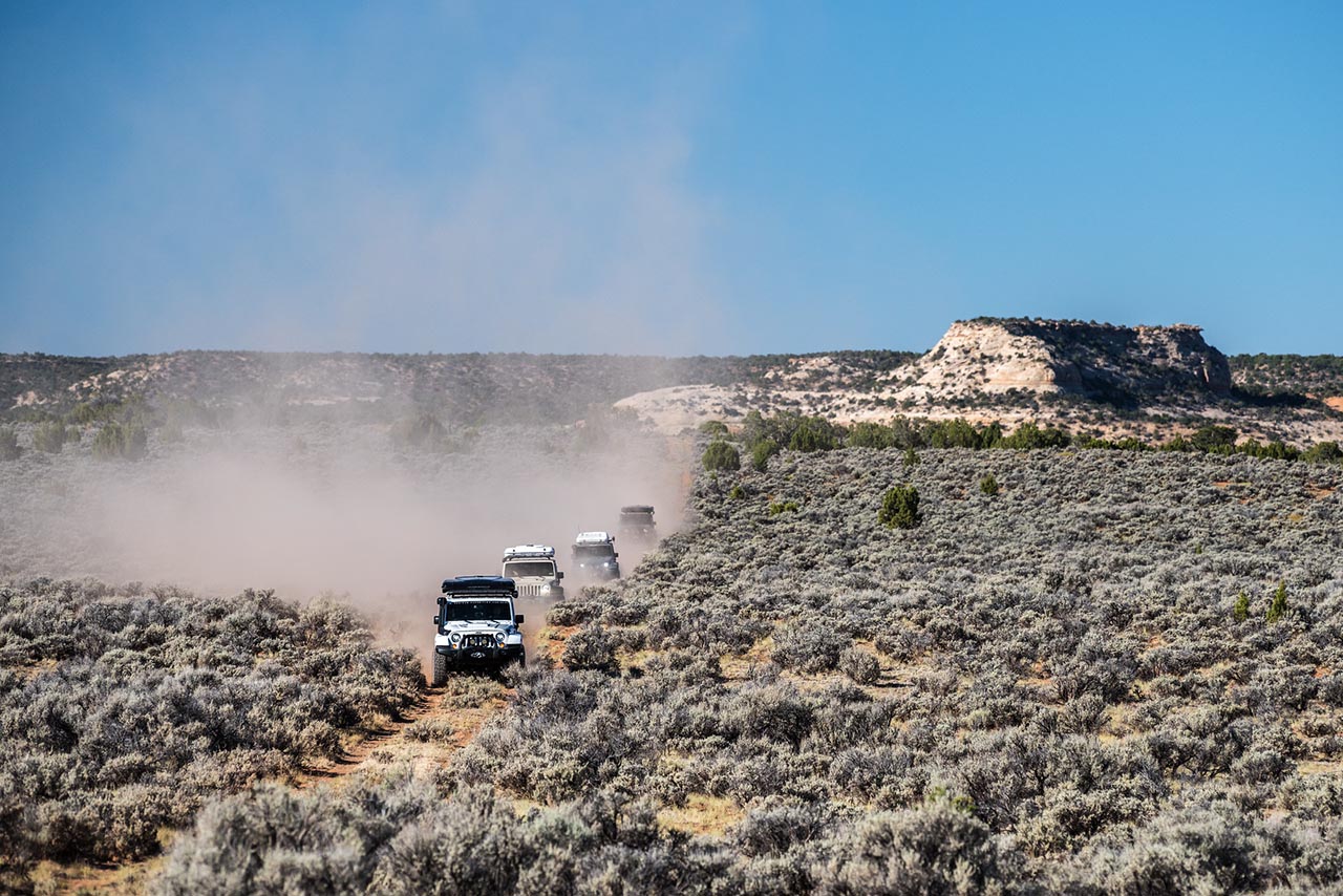 Group of Jeeps driving down the road, shot from a distance